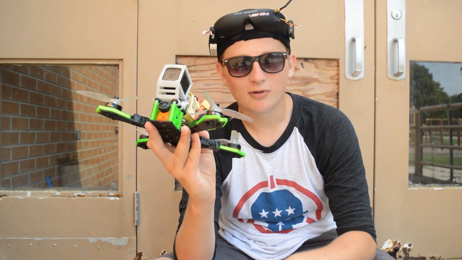 Nicholas holding an FPV aircraft with goggles above his sunglasses
