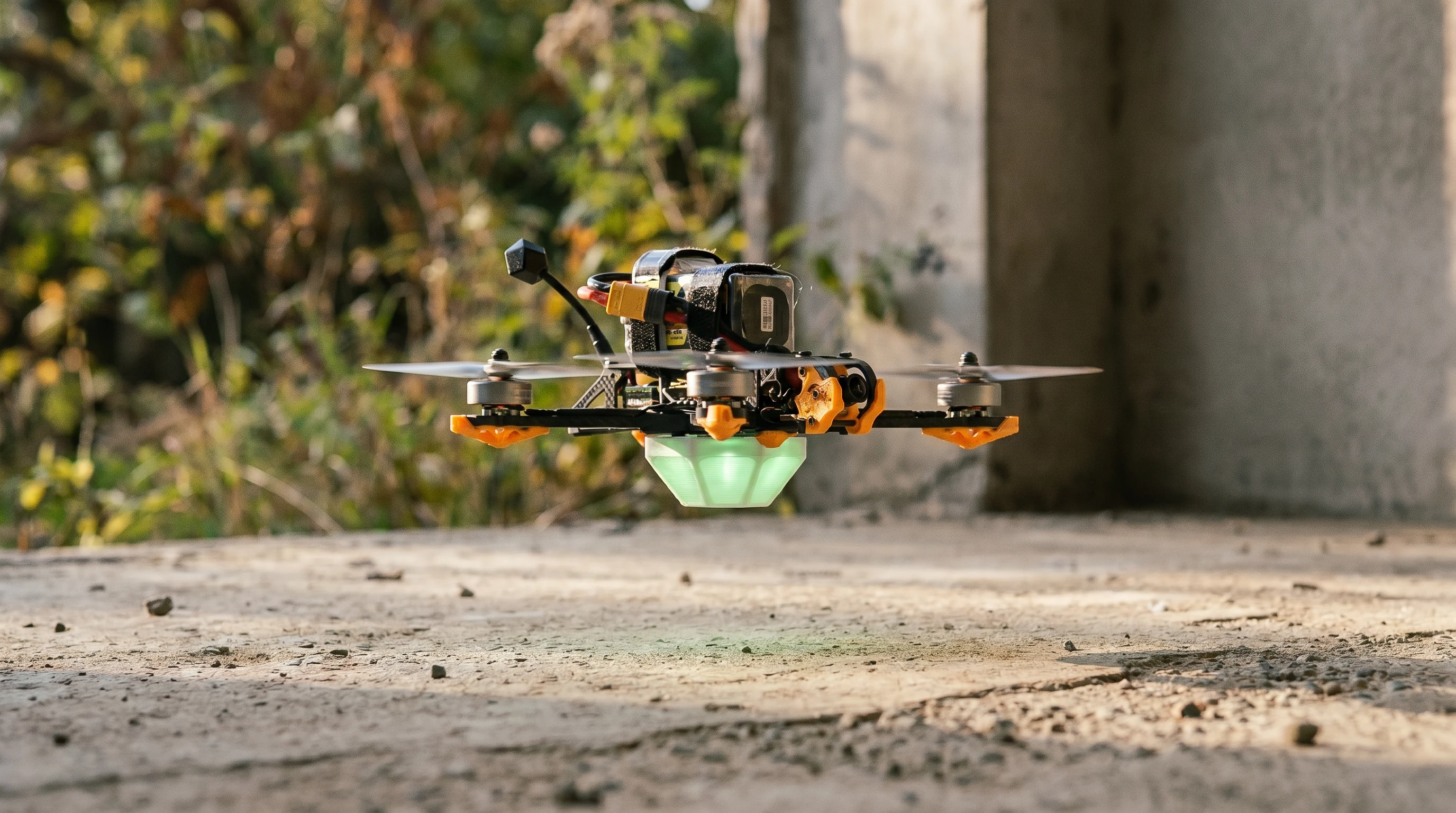FPV quadcopter concept with a green-illuminated Arena Go! capsule underneath