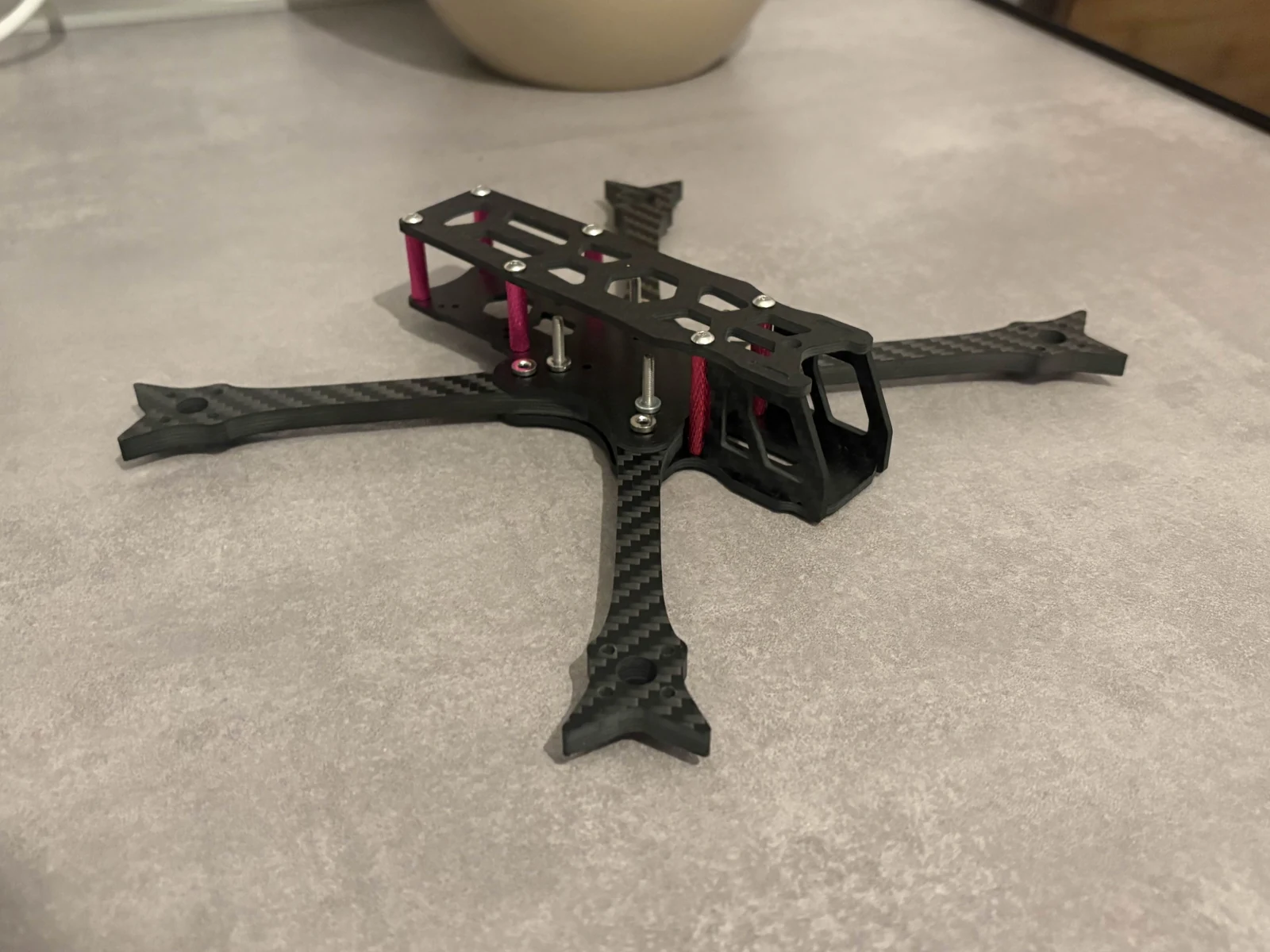 Parallax carbon-fiber FPV prototype frame with printed camera housing and standoffs.